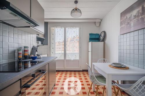une cuisine avec une table et un réfrigérateur blanc dans l'établissement R Apparts T4 Sweet Home, à Grenoble