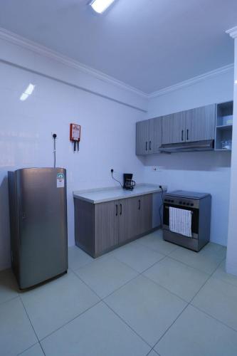 an empty kitchen with a refrigerator in a room at Rige's Homes 2Brm Furnished in Nairobi