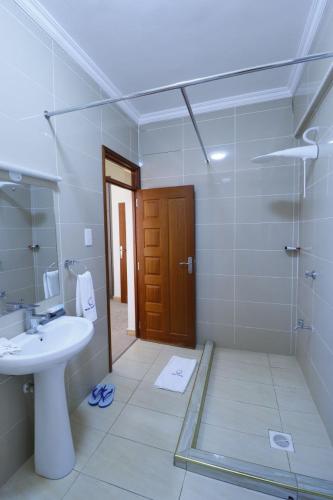 a bathroom with a sink and a toilet and a shower at Rige's Homes 2Brm Furnished in Nairobi
