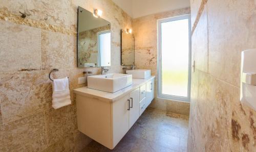 ein Badezimmer mit zwei Waschbecken und einem Spiegel in der Unterkunft Villa Collie Luxury Retreat7 King Master Brmaid in Sosúa