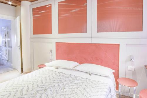 a bedroom with a white bed with a red headboard at Albergo Diffuso - Il Poggetto tra Urbino & San Marino in Urbino