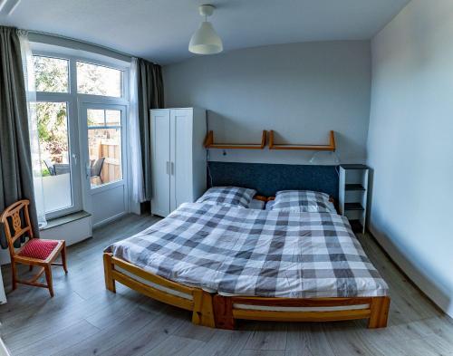 una camera da letto con un letto con una coperta scozzese e una finestra di Ferienwohnung-Krabbe a Dornum