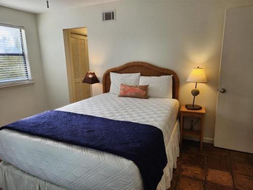a bedroom with a large bed with a blue blanket at Blue Haven in Coffeyville