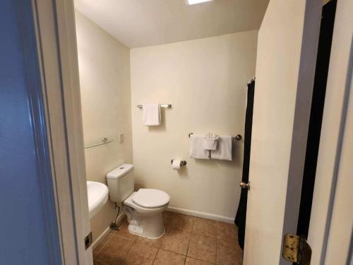 a bathroom with a toilet and a sink and towels at Blue Haven in Coffeyville