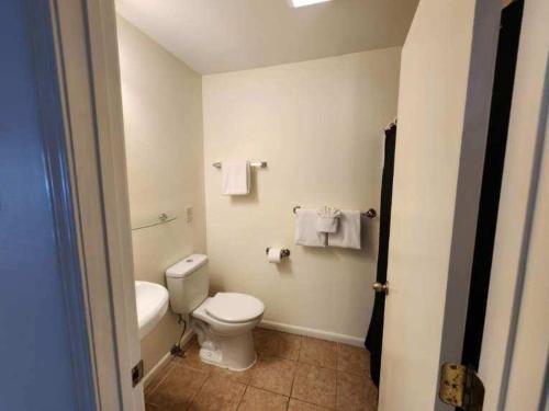 a bathroom with a toilet and a sink and towels at Blue Haven in Coffeyville