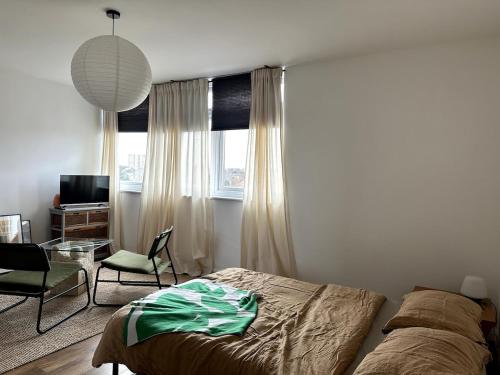 a bedroom with a bed and a chair and a window at Flat-on-Sea in Southend-on-Sea