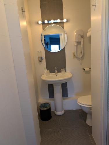 a bathroom with a sink and a mirror and a toilet at A Fleur de Couette in Auvelais