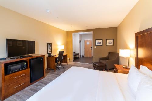a hotel room with a bed and a flat screen tv at Sonesta Essential - Baton Rouge Airport in Baton Rouge