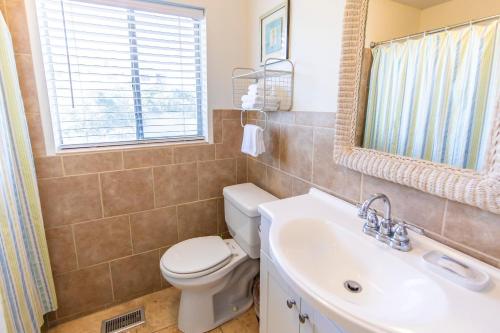 a bathroom with a toilet and a sink and a mirror at Whispering Sands 1A in Coffeyville