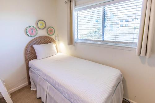 a small bedroom with a bed and a window at Whispering Sands 1A in Coffeyville