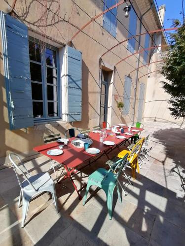 - une table de pique-nique avec des chaises et des assiettes dans l'établissement Croassecorbeau Maison de Famille au pied du Ventoux, à Malaucène