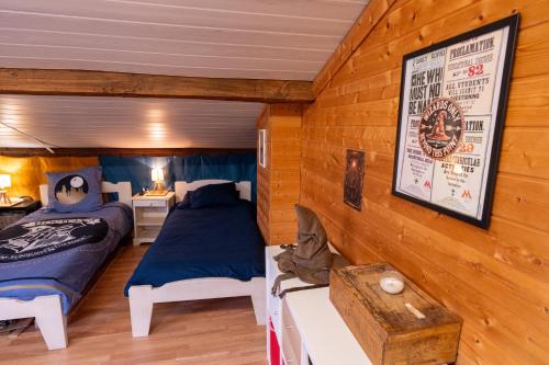 a bedroom with two beds in a room with wooden walls at Chez Simon, au fil de l'eau in Revel