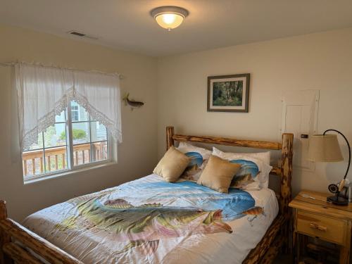 a bedroom with a bed with a wooden frame and a window at Wapato Lake Waterfront Retreat in Manson