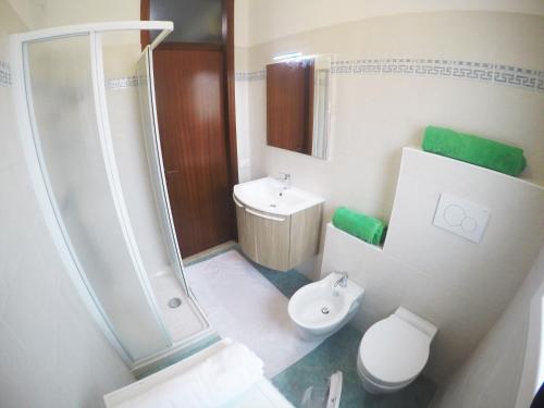 y baño con aseo, ducha y lavamanos. en Appartamento Tintoretto - Agenzia Cocal, en Caorle