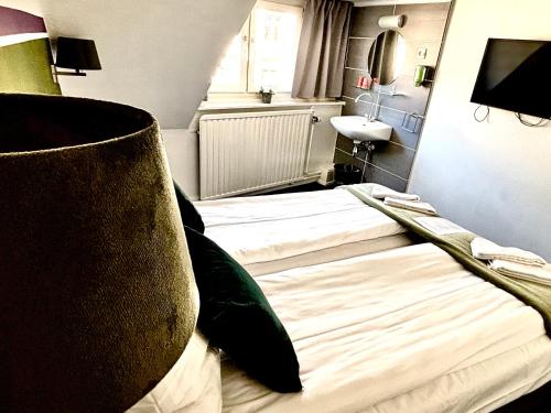a bedroom with two beds and a sink at Le Bistro in Valkenburg