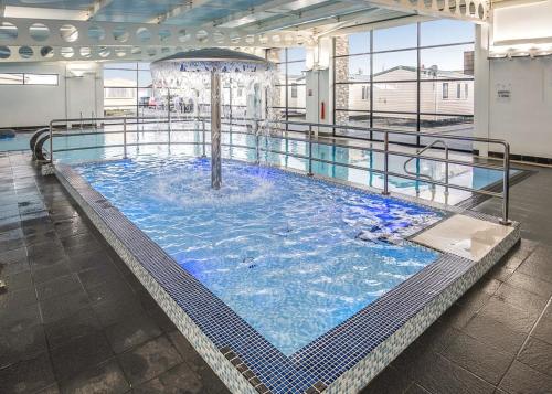 a large swimming pool in a building at Whitehouse Holiday Park in Abergele
