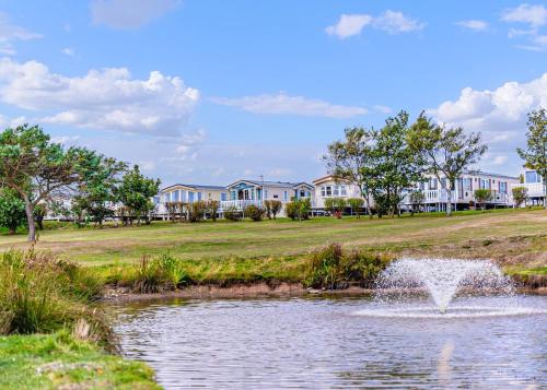 a fountain in a pond in front of a building at Willows Holiday Park in Withernsea