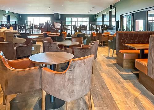 a restaurant with tables and chairs in a room at Willows Holiday Park in Withernsea