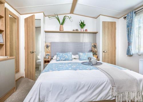 a bedroom with a large bed with blue pillows at Willows Holiday Park in Withernsea