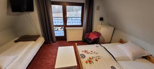 a small room with two beds and a window at Willa Gorska Koleba in Zakopane