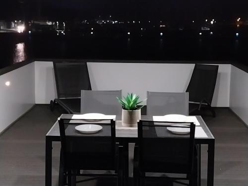 a table and chairs on a balcony at night at Floating House - LUXURY Floating Sea OASIS Pula in Pula