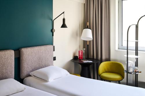 a hotel room with two beds and a chair at Ibis Praha Wenceslas Square in Prague