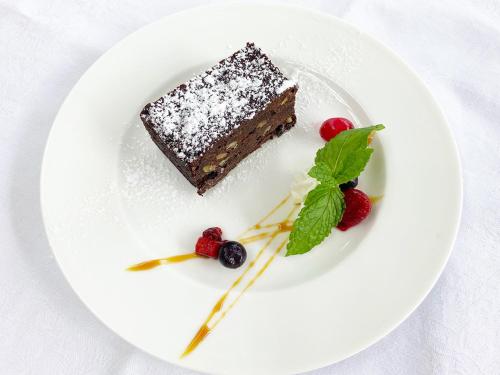 a piece of chocolate cake on a white plate with berries at Hotel Euro City in Nikko