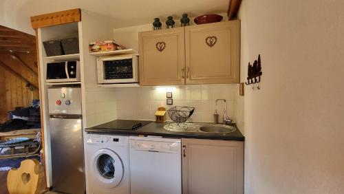 une cuisine avec un évier et une machine à laver dans l'établissement Alpen Marvel, à Morillon