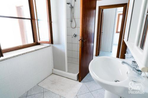 a white bathroom with a sink and a shower at Malamuri 5 sun vacanze in Budoni