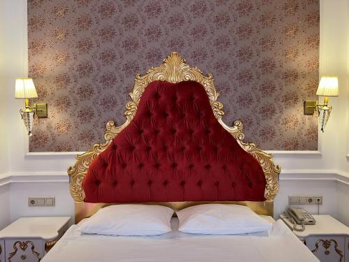 a red headboard of a bed in a room at Royal Grand Hotel in Kyiv