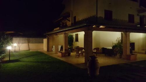 a dog standing in front of a house at night at Appartamenti Gli Ulivi Di Maremma in Gavorrano