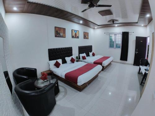 a bedroom with two beds and a table and chairs at Golden Oak Villa Mussoorie in Rājpur