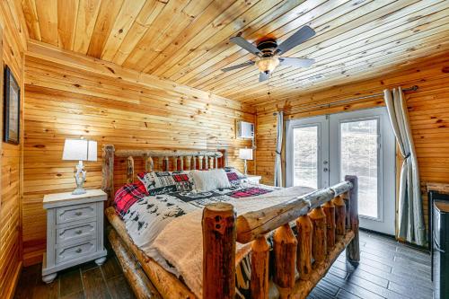 a log cabin bedroom with a bed and a ceiling fan at about 1 Mi to Dollywood Family Home with Pool and Hot Tub in Pigeon Forge