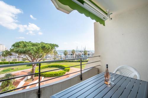 d'un balcon avec une table et une vue sur un parc. dans l'établissement Rêve Bleu Résidence La Grande Pyramide Vue Port Hyper Centre Wifi Parking Privé Gratuit, à La Grande Motte