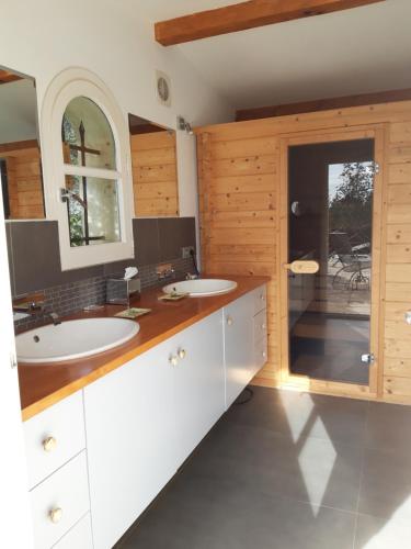 une salle de bain avec deux lavabos et un grand miroir dans l'établissement Magnifique logement indépendant dans villa avec piscine, à Tanneron