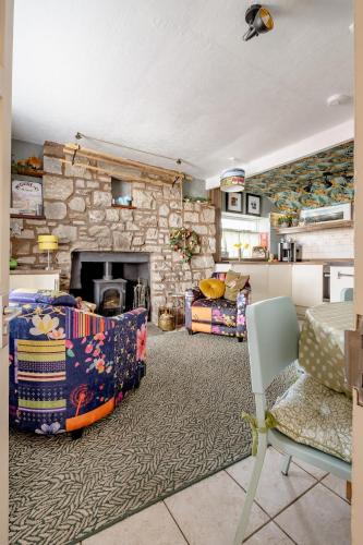 a living room with a fireplace and a stone wall at Loch Ness village cottage for 2 with free parking & pets welcome in Drumnadrochit