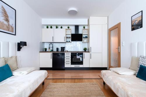 Una sala de estar con dos sofás y una cocina. en Family Arena Prague, en Praga