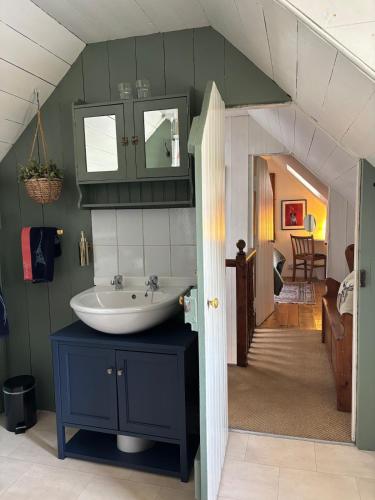 a bathroom with a sink and a room at Loch Ness village cottage for 2 with free parking & pets welcome in Drumnadrochit