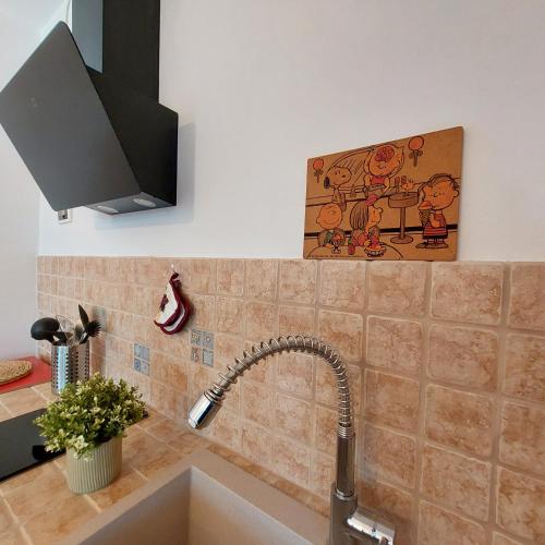 a kitchen sink with a faucet and a painting on the wall at Dama35 - Tuscany holiday house - Casentino-La Verna in La Verna