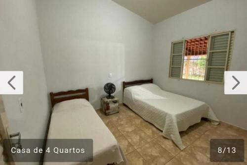 a bedroom with two beds and a window at Sitio jardim da canastra in São Roque de Minas