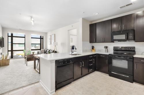 a kitchen with black and white appliances and a living room at The Leisure & The Work Mixed In One-Site in Arlington