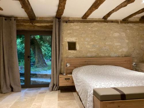 une chambre avec un lit et une grande fenêtre dans l'établissement Vialard, à Salignac Eyvigues