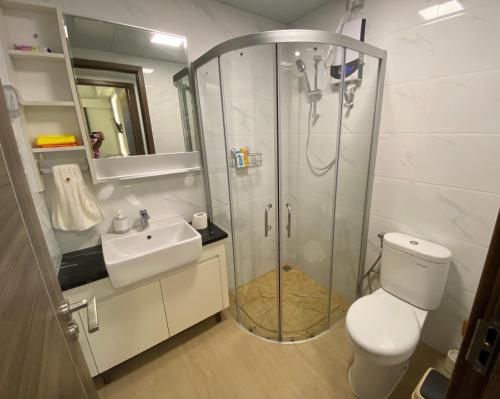 a bathroom with a shower and a toilet and a sink at Sky House BSD in Samporo