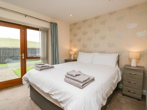 une chambre avec un lit blanc et une fenêtre dans l'établissement 7 Sandpiper, à Carnforth