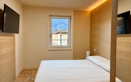 a bedroom with a bed and a window at Casa Elena - Lake view in Verceia