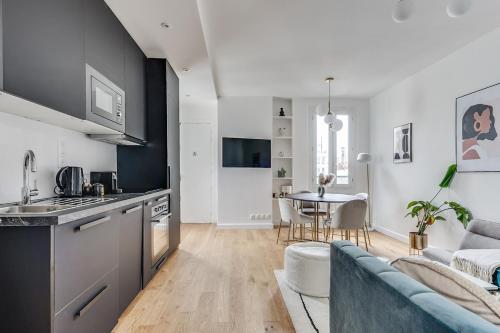 une cuisine et un salon avec un canapé et une table dans l'établissement Intemporel, à Paris
