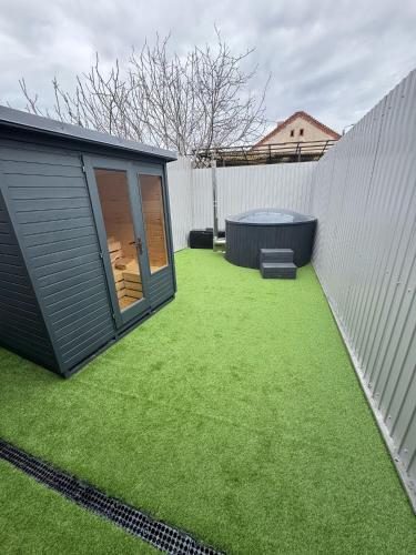 a small backyard with a hot tub next to a fence at Moft Hotel Apartments Free Parking Self Check-In in Oradea
