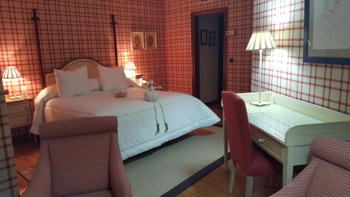 a bedroom with a bed and a table and two chairs at Hotel Presa in Riaño