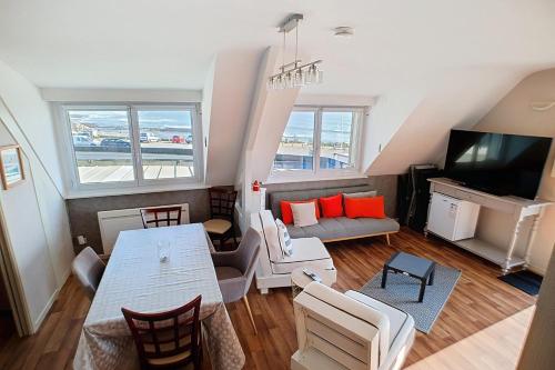 un salon avec une table et une télévision dans l'établissement Tipoz'Immo- l'Océan Duplex sea view-access on foot, à Pouldreuzic
