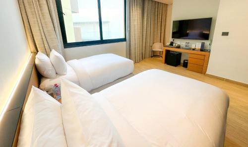 a hotel room with two beds and a television at voco Dubai Monaco, the Heart of Europe by IHG in Dubai